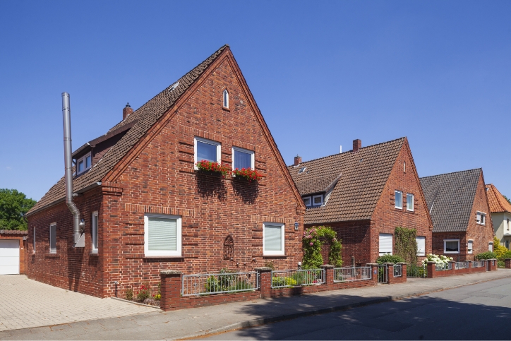 Reihenhäuser aus rotem Backstein in einer Wohnstraße.
